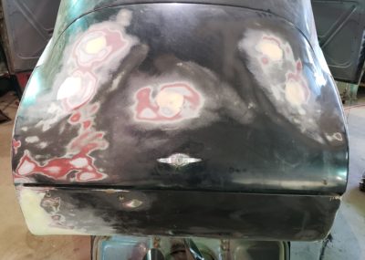 Trunk lid with minor dent repair and holes plugged